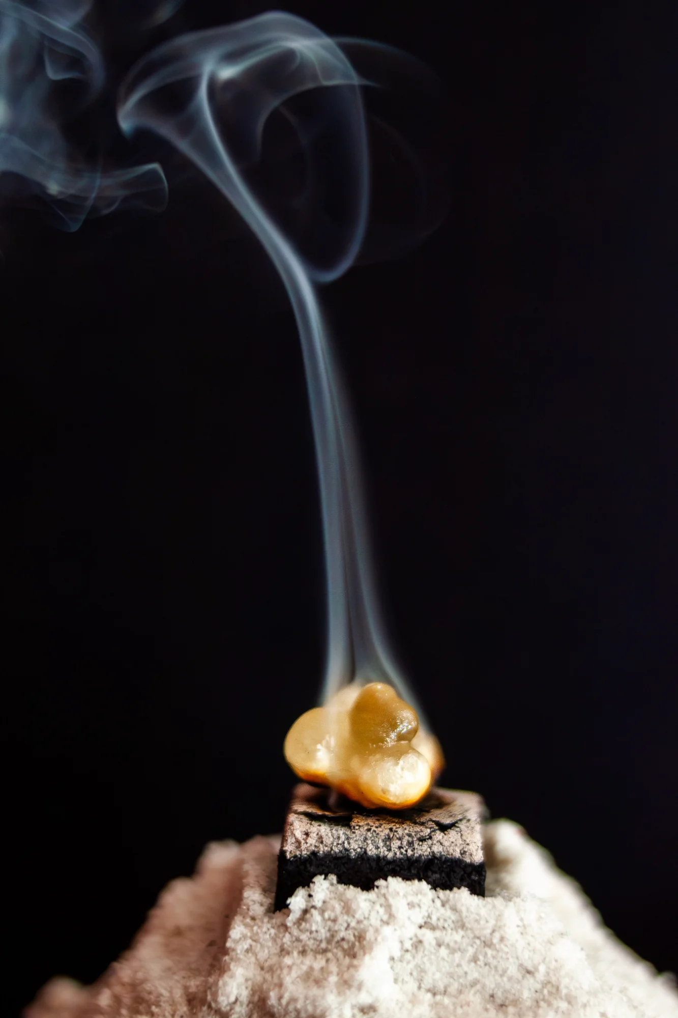 Frankincense resin burning with swirling smoke